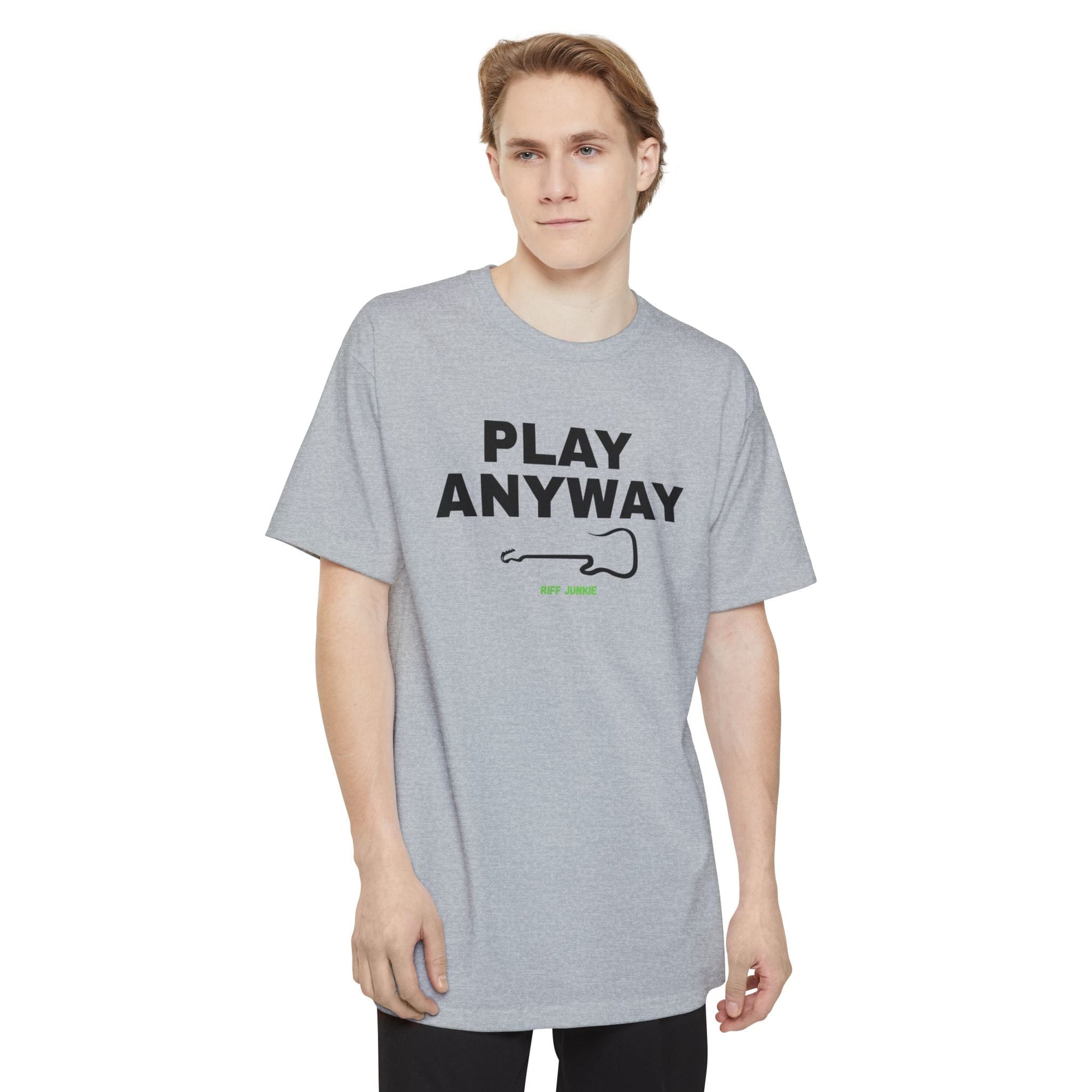 A man wearing a navy short-sleeve t-shirt with a graphic on the chest that reads 'PLAY ANYWAY' in beige block letters above a beige guitar outline and small green 'Riff Junkie' text, shown on a plain white background.
