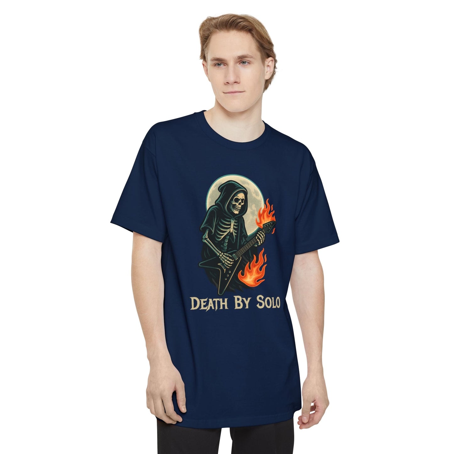 A man wearing a navy short-sleeve t-shirt featuring a graphic of a grim reaper playing a guitar with flames, set against a full moon, with the text 'DEATH BY SOLO' printed below.