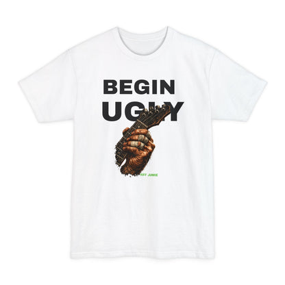 A white short-sleeve t-shirt featuring a graphic print on the front. The design displays the text 'BEGIN UGLY' in a distressed cream-colored font above an illustration of a hand holding a guitar, with  "Riff Junkie" in neon green.